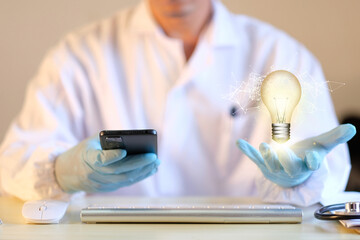 Poster - Doctor's hands hold a light bulb in a new concept with innovation and inspiration. Hologram virtual interface for medical technology, digital healthcare and network connectivity.