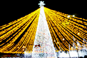 Wall Mural - Blurred and bokeh of bright Christmas tree lighting on night time background.