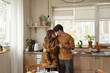 © Clique Images - Married couple in love wearing casual outfit spending time together standing in modern kitchen horizontal shot