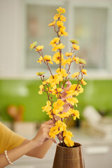 Woman Putting Flowers in Vase