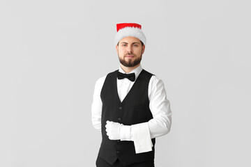 Sticker - Handsome male waiter in Santa hat on grey background