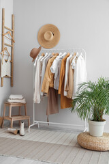Wall Mural - Interior of light dressing room with rack, clothes and stepladder