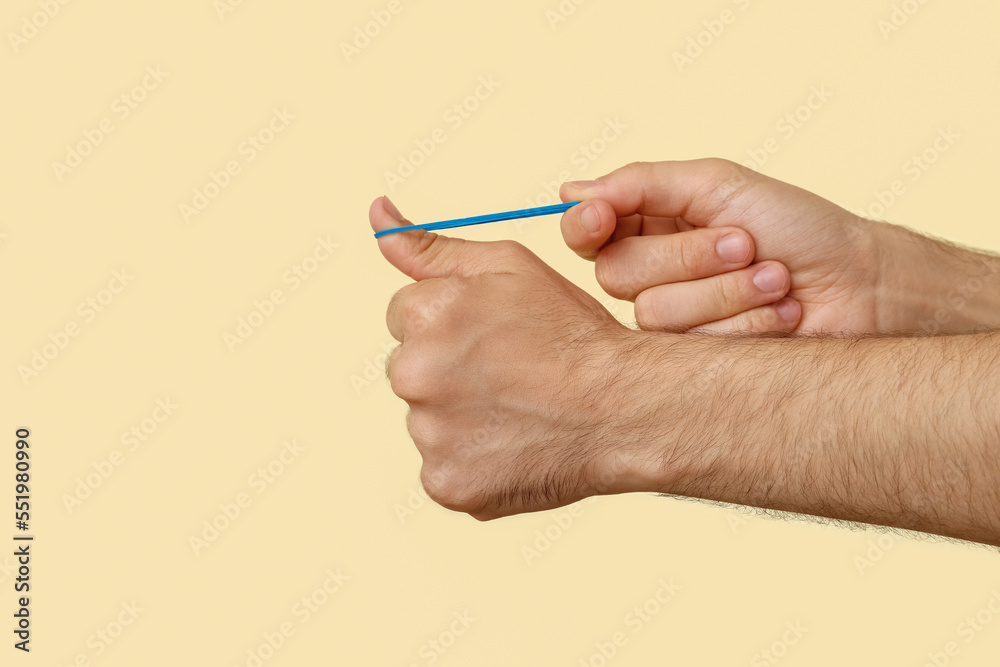 Man with blue rubber band on beige background