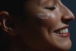 Young beautiful happy woman applying cream on her face