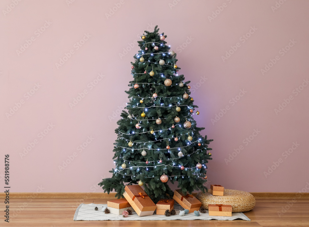 Glowing Christmas tree with presents in living room