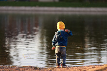 Boy Throws Stones Into The Water