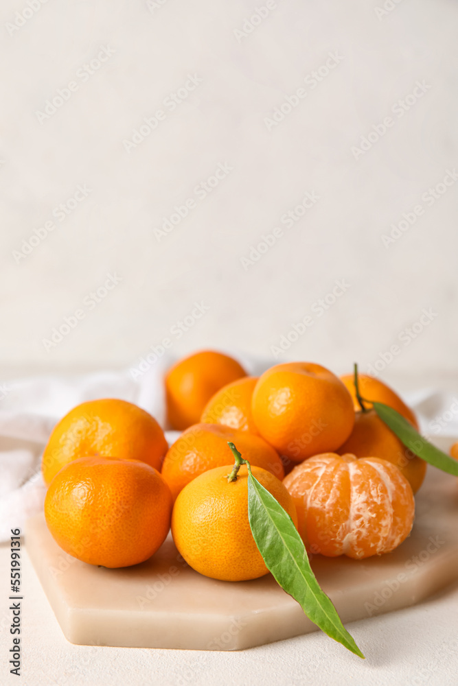 Board with fresh ripe tangerines on light background, closeup