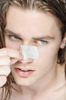 © Clique Images - Portrait of handsome young man using cleansing nose strips after taking shower in morning