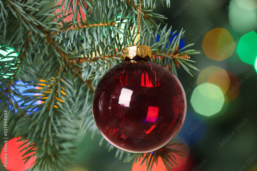 Red Christmas ball hanging on fir tree, closeup
