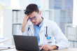© Ilzer VH/peopleimages.com - Doctor man, laptop or headache stress in hospital office or medical test results, life insurance fail or surgery planning crisis. Anxiety, mental health or burnout for healthcare worker on technology