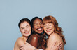© Jacob Lund - Group of happy women with different skin tones smiling and embracing each other in a studio