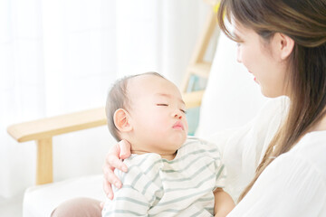 Wall Mural - 家で眠る赤ちゃんを抱っこする母親