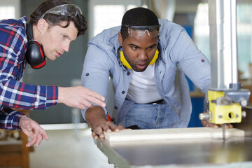 two carpenter works on woodworking the machine tool