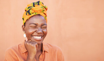 Black woman, face and smile with a turban and free space for African culture, happiness and beauty mockup on peach background. African female with Nigeria tradition fashion head scarf while laughing