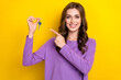 Photo of cheerful shiny girl dressed purple pullover pointing finger keys isolated yellow color background