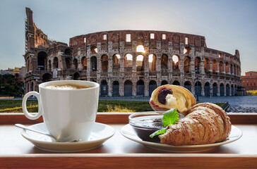 Wall Mural - Famous Colosseum against cup of fresh coffee with croissant in Rome, Italy