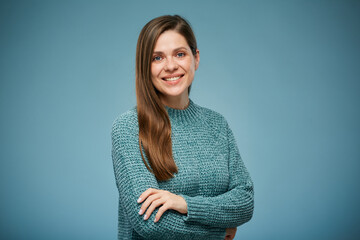 Smiling woman in casual blue clothes standing with arms crossed. Advertising female studio portrait on blue.