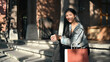 © Prathankarnpap - Portrait of stylish woman with shopping bags sitting on stairs in the shopping district of a city. Shopping, tourism and lifestyle concept