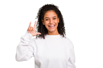 Young Brazilian curly hair cute woman isolated showing a horns gesture as a revolution concept.