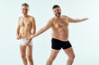 © oneinchpunch - Two multiethnic men posing for a male edition body positive beauty set. Shirtless guys with different age, and body wearing boxers underwear