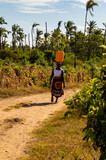 Fototapeta Sawanna - Woman carrying a water canister on her head