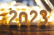 Leinwandbild Motiv wooden number 2023 onchristmas beautifull shiny gold background. sparkle festive blurred bokeh