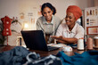 © Beaunitta V W/peopleimages.com - Fashion design, laptop and collaboration of designer team or black women talking, planning vision idea and reading SEO feedback at night. Entrepreneur females with technology for marketing sales