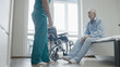 Clinical worker assisting elderly patient in rehabilitation center, treatment