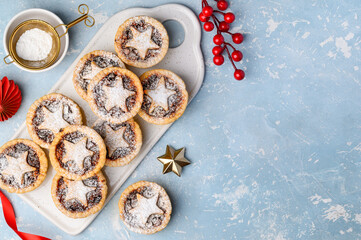 Traditional Christmas dessert with dried fruits - mince pies on a blue background. Top view