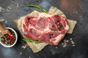 Poster - meat with seasoning. Pieces of raw pork steaks with rosemary and pepper on a dark background. banner, menu, recipe place for text, top view