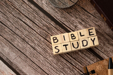 Wall Mural - Bible study text written on wooden cubes , holy Bible book, notebook, pen, and magnifying glass on wooden background. Copy space. Top table view.