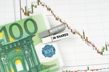 On the charts of quotes are the euro, clothespins with the inscription - Investment in shares