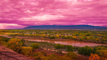 Stormy Pink Sunset Cloudscape Over Albuquerque Skyline, Autumn Landscape With Colorful Cottonwood Trees Over Rio Grande River, New Mexico, USA
