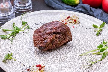 Sticker - grilled steak filet Mignon on grey plate on dark stone table macro close up