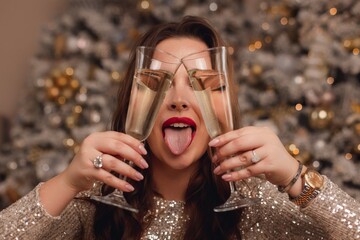 a girl in a shiny silver dress celebrates the new year. cheerful holiday mood.