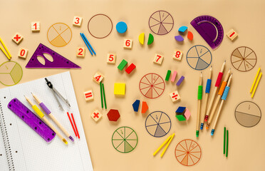 Set of supplies for mathematics and for school. Fractions, rulers, pencils, notepad on beige background. Back to school, fun education concept