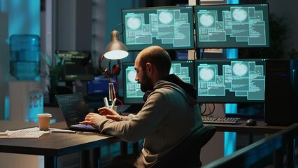 Frustrated hacker using computer to break into corporate data servers, working under pressure. Infecting software system with dangerous network virus, stealing security information. Tripod shot.