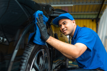 Wall Mural - Man worker washing car service with micro fiber. Car wash cleaning wipe station. Employees clean a vehicle professionally detailing.