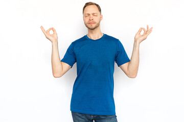 Relaxed man standing and showing zen gesture. Peaceful man standing in lotus position on white background, meditating with closed eyes and breathing. Yoga, relaxation concept