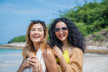 Wall Mural - Happy women with friend are playing on the beach While relaxing on vacation for the weekend on sunny day.