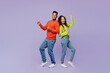 © ViDi Studio - Full body side view fun young couple two friends family man woman of African American ethnicity in casual clothes together point finger aside on area isolated on pastel plain light purple background