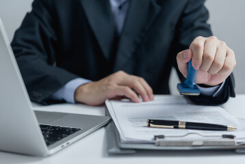 Wall Mural - Man stamping approval of work finance banking or investment marketing documents on desk.