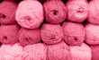 Yarn Balls Wool in a Fabric Shop. Background from colored acrylic yarn. Skeins of thread close-up. Materials for needlework, for knitting and crocheting. Color Of The Year 2023 - Viva Magenta