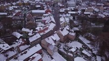 Aerial View Of Kuldiga Old Town (UNESCO Heritage) With Red Roof Tiles Covered By Snow, Overcast Winter Day, Wide Birdseye Drone Shot Moving Forward
