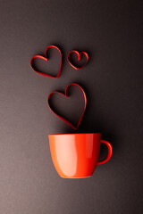 Sticker - Vertical of red heart shapes rising from red mug on dark grey background, with copy space