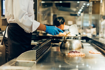 Wall Mural - Hand of man take cooking of meat with vegetable grill, Chef cooking wagyu beef in Japanese teppanyaki restaurant