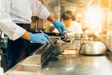 Wall Mural - Hand of man take cooking of meat with vegetable grill, Chef cooking wagyu beef in Japanese teppanyaki restaurant