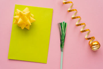 Wall Mural - top view of greeting card near serpentine and drinking straw on pink background.