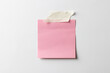 Pink sticky memo note with tape and copy space on white background