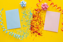 Top View Of Blue And Pink Greeting Cards Near Sprinkles And Serpentine On Yellow Background.